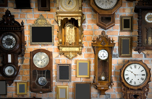 Collection of vintage clock and picture frame hanging on an brick wall