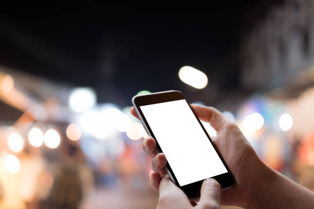 istock Woman's hand holding smartphone with blank copy space screen with night light bokeh background. 962741854