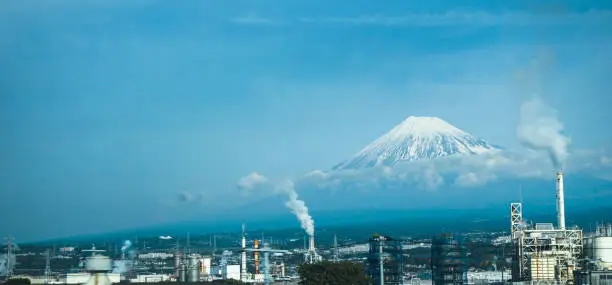White smoke from the industrial make the contrast scenery with mount fuji look behind