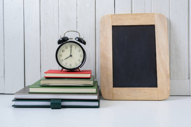 istock education workspace background concepts alarm clock on exercise books with White wooden vintage wall 962749038