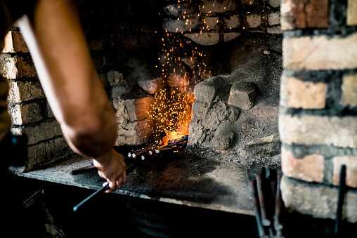 Manual worker heating a metal workpiece.Blacksmith's workshop in Malaysia