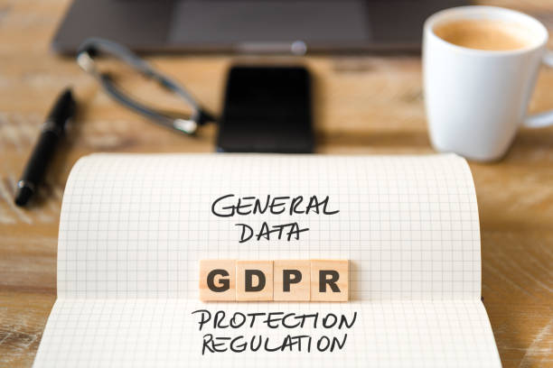 istock Closeup on notebook over wood table background, focus on wooden blocks with letters making GDPR General Data Protection Regulation text 962756266