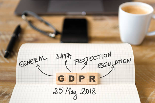 istock Closeup on notebook over wood table background, focus on wooden blocks with letters making GDPR General Data Protection Regulation text 962756366