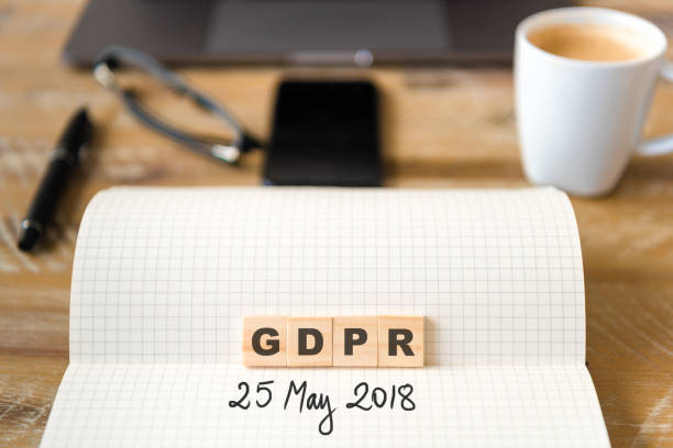 istock Closeup on notebook over wood table background, focus on wooden blocks with letters making GDPR General Data Protection Regulation text 962756880