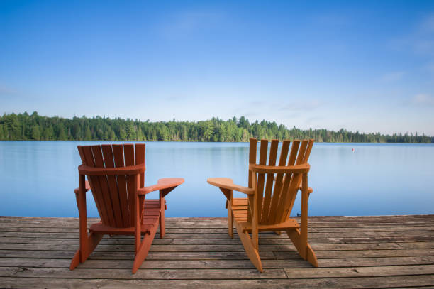 Muskoka chairs on a wooden dock stock photo