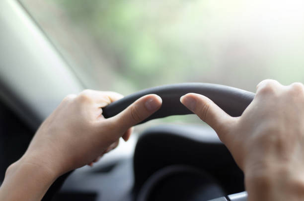 istock Female hands on car steering wheel. Travel concept. 962761152