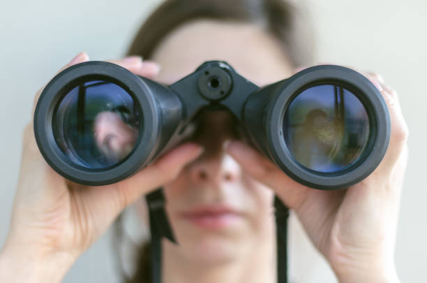 Young woman. Girl looking through the binoculars. Find and search concept. searching binoculars stock pictures, royalty-free photos & images