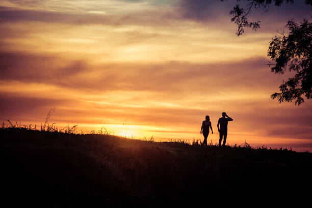 istock Couple walking by the sunset, silhouette 962765144