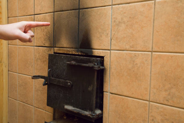 istock Man's hand pointing to the soot marks from furnace on tiles wall. Problem and solution concept. 962766378