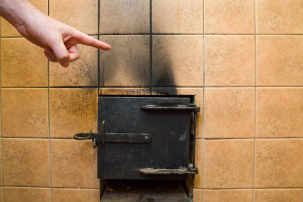 Man's hand pointing to the soot marks from furnace on tiles wall. Problem and solution concept.