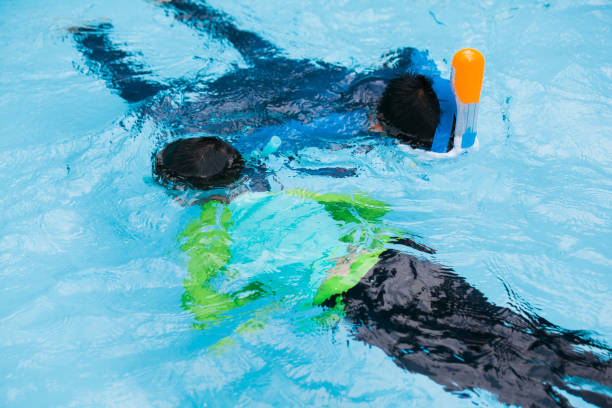 istock Boys studying snorkeling in swimming pool 962771556