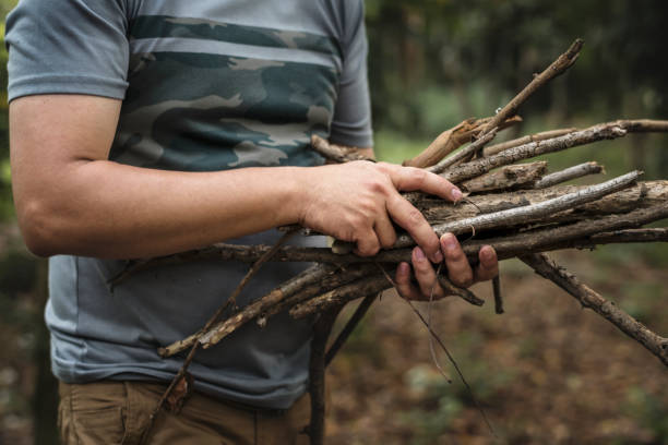 istock Man collecting dry twigs for bonfire 962781014