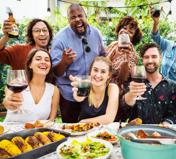 Group of diverse friends enjoying summer party together Group of diverse friends enjoying summer party together pot luck stock pictures, royalty-free photos & images