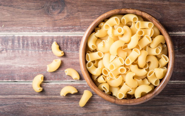istock Raw macaroni on wooden background,Top view 962787704