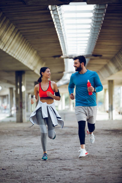 istock Fit attractive couple running outdoors together 962790250