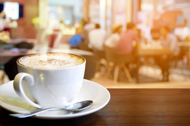 istock Cappuccino on the table with blur people in food center 962800376