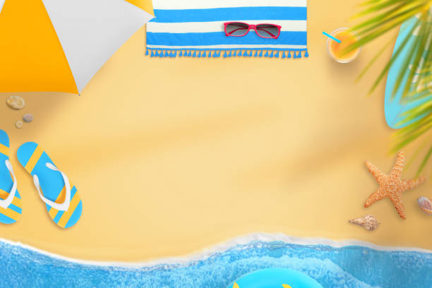 Beach towel with beach accessories on sandy tropical beach top view with copy space