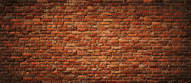 Section of an old brown brick wall.