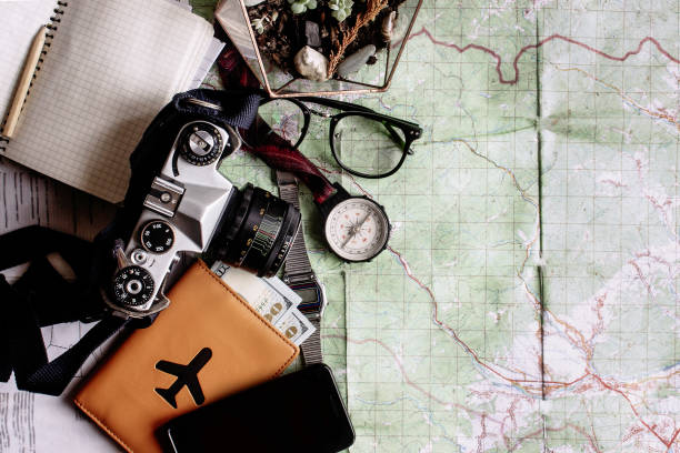 istock wanderlust and adventure concept, compass camera phone passport money notebook  on map, top view, space for text, vintage toned image 962803878