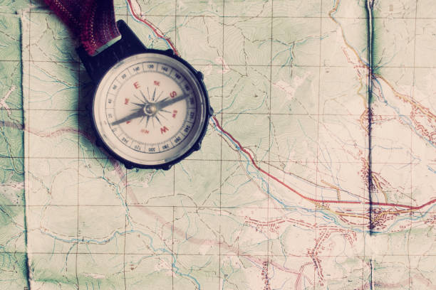 istock wanderlust and explore concept, old compass lying on map, top view, space for text, vintage toned image 962803930