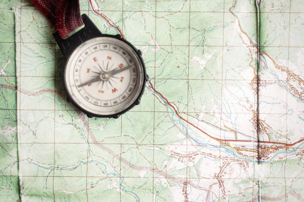 istock wanderlust and explore concept, old compass lying on map, top view, space for text, vintage toned image 962804142