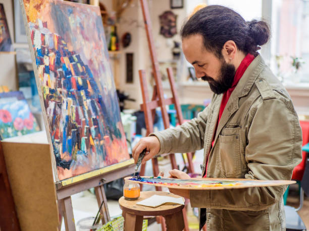 istock middle aged male artist drawing picture in studio 962804816