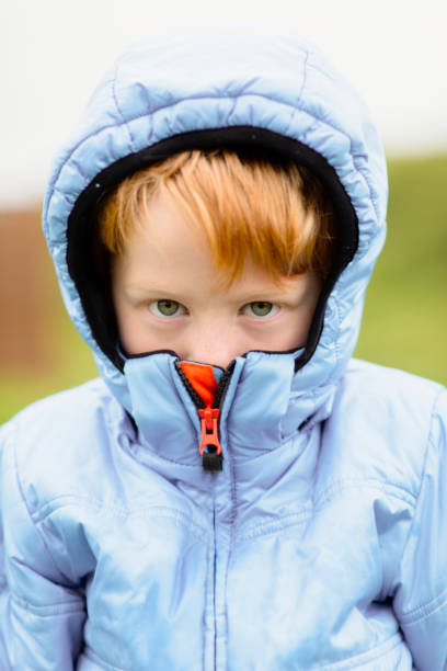 istock Portrait of boy covering face with jacket 962814998