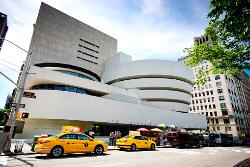 Guggenheim Museum in New York with visitors going into the entrance. Museum was designed by Frank Lloyd Wright and building opened on October 21, 1959.