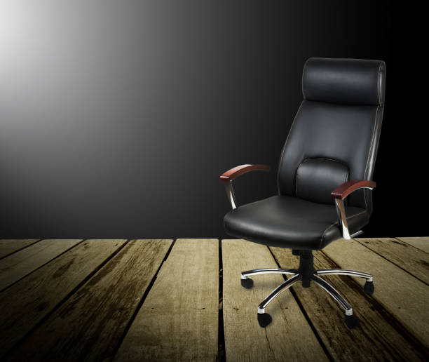 istock Black leather office chair on wood floor,dark background 962828588
