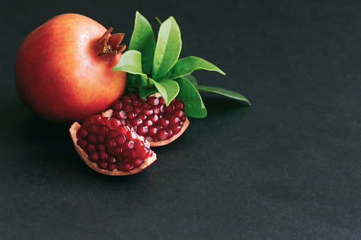 Top view of different types of fruits on a white surface. Strawberries, raspberries, peaches, figs, apples, plums, oranges and pomegranates on the table.
