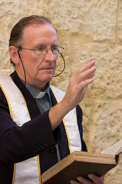 Priest with Bible ... giving a blessing anglican stock pictures, royalty-free photos & images