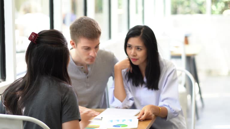 Couple having conversation discussing personal finance document loan contract, real estate purchase with sale represent.