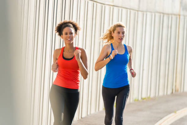 istock Two female athletes running together 962846116