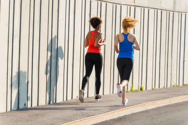 istock Two female athletes running together 962846122