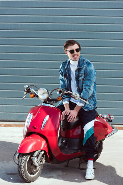 istock happy young man on vintage red scooter looking away 962858502