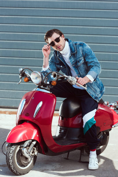 istock handsome young man on vintage red scooter looking at camera 962858556
