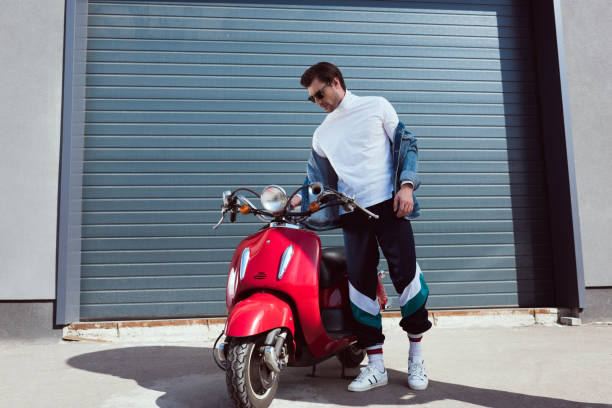 istock handsome young man in vintage clothing with red scooter 962858912