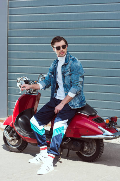 istock young man in stylish vintage clothes sitting on scooter 962859958