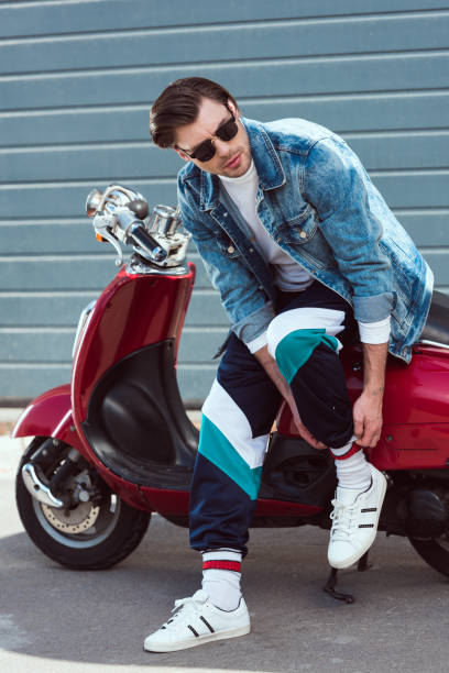 istock young man in stylish denim jacket with vintage scooter 962860082