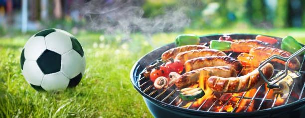 grilled sausage on the flaming grill and soccer ball - sausage bratwurst barbecue grill barbecue imagens e fotografias de stock