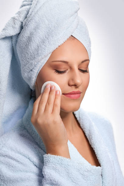 istock Attractive woman in bathrobe cleaning her face 962865820