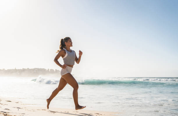 istock Happy woman running at the beach 962866886