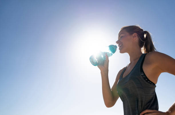istock Athletic woman at the beach drinking water 962867034