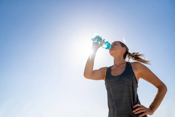 istock Athletic woman at the beach drinking water 962867102