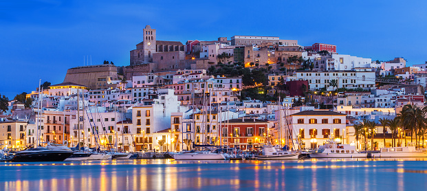 Ibiza Dalt Vila downtown at night with light reflections in the water, Ibiza, Spain.