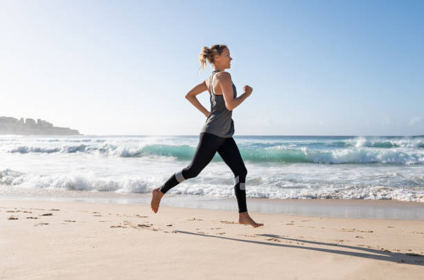 istock Beautiful woman running at the beach 962869580