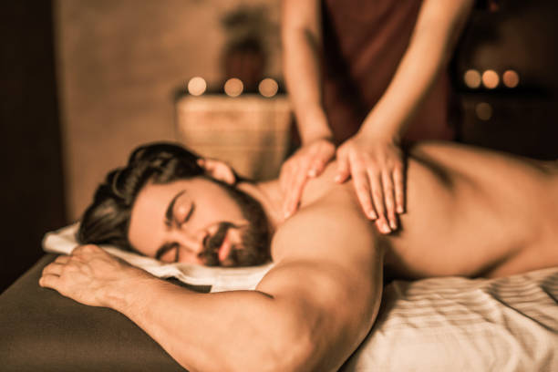 Relaxed mid adult man enjoying a back massage. Relaxed mid adult man enjoying a back massage. man massage stock pictures, royalty-free photos & images