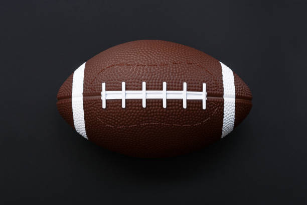 american football isolated on black background . sport object concept - junior high fotos imagens e fotografias de stock
