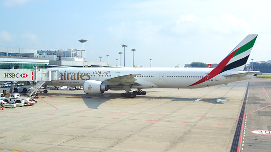 SINGAPORE - APR 4th 2015: Emirate Boeing 777-300ER plane at the gate at Changi Airport. Emirates is the largest airline in the Middle East.