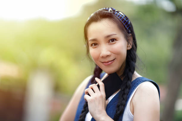 Asian woman happy to use smart phone outdoors